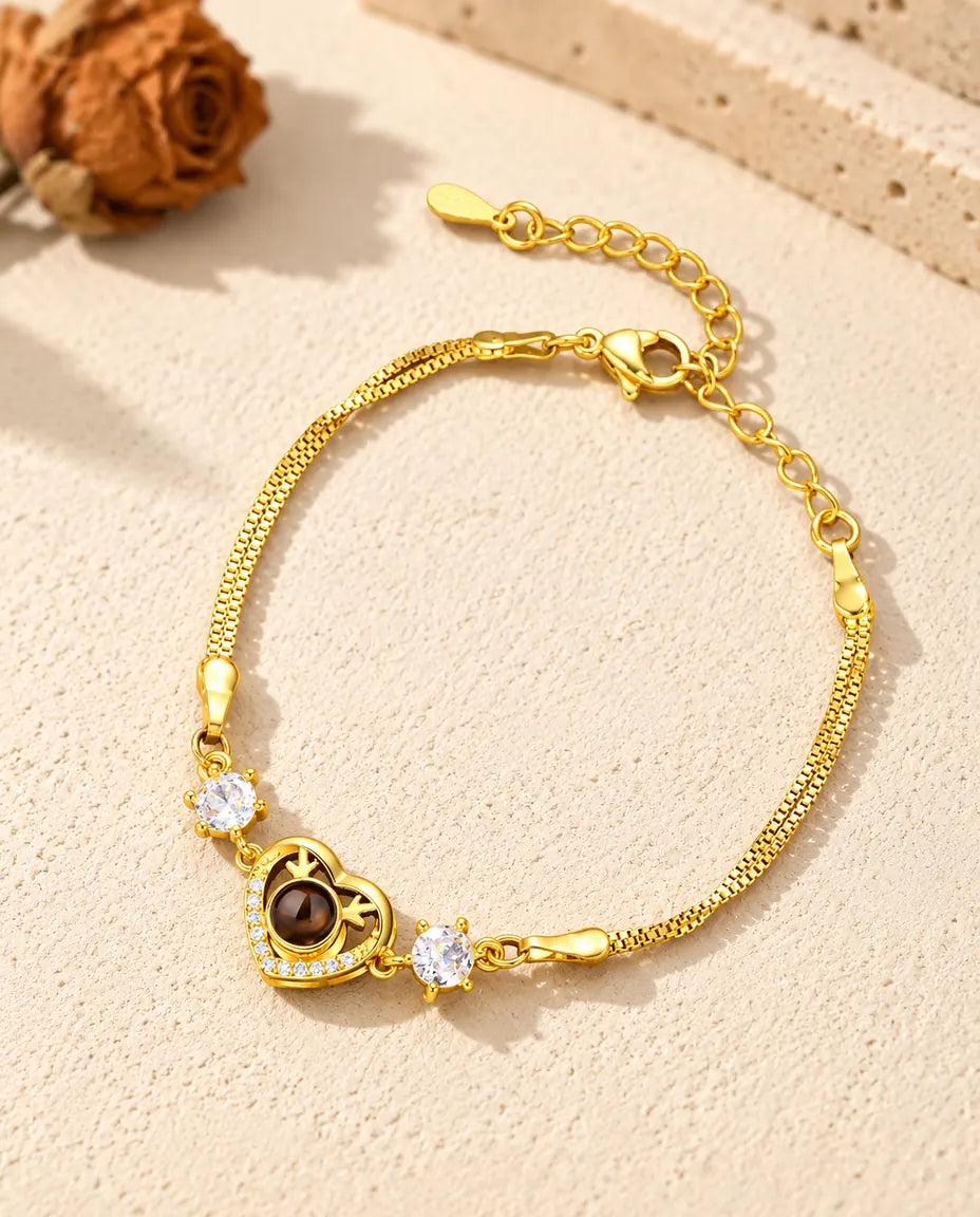 Bracelet cœur doré aux zircons avec fermoir mousqueton et chaîne de rallonge sur plâtre clair