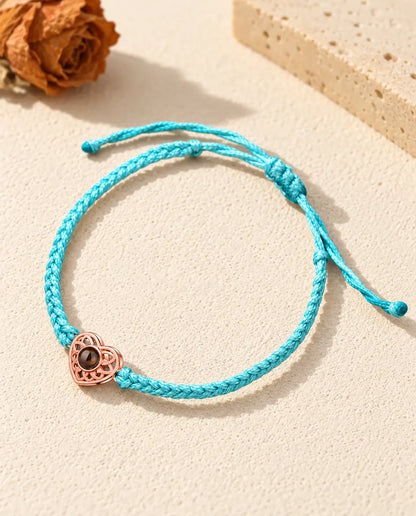 Cœur ajouré couleur or rose sur un cordon fin tressé bleu avec nœud coulissant réglable