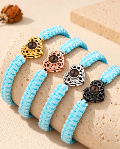 Bracelets cordon tressé bleu clair alignés sur un bloc de travertin, cœur dans chaque couleur