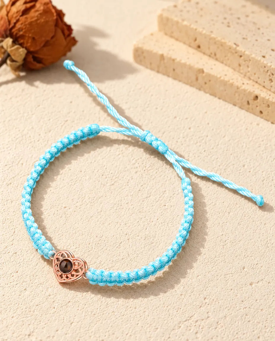 Cœur ajouré couleur or rose sur un cordon tressé bleu clair avec nœud coulissant réglable