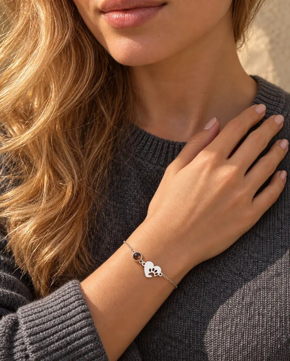 Femme, les doigts sur la clavicule, portant le bracelet cœur empreinte de patte argenté