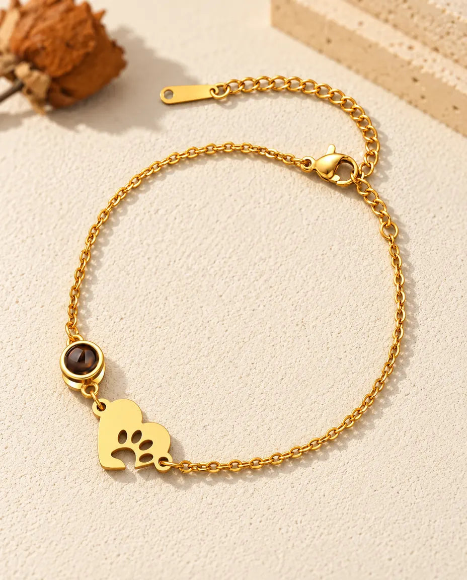 Bracelet souvenir animal doré avec cœur empreinte de patte et chaîne de rallonge sur plâtre clair