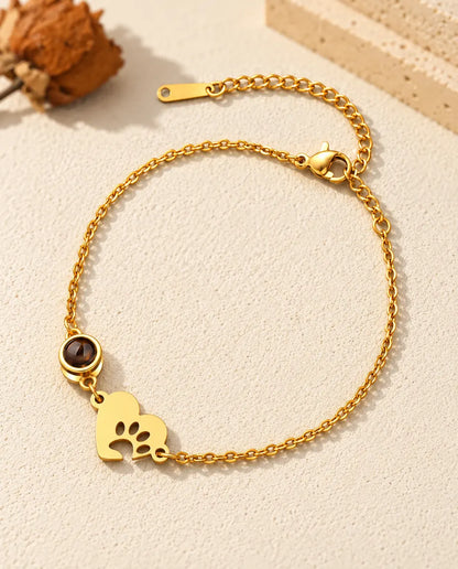 Bracelet souvenir animal doré avec cœur empreinte de patte et chaîne de rallonge sur plâtre clair