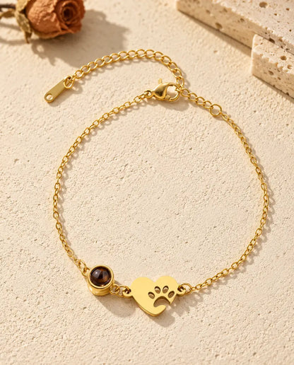 Vue de dessus du bracelet cœur empreinte de patte doré avec photo dans la pierre