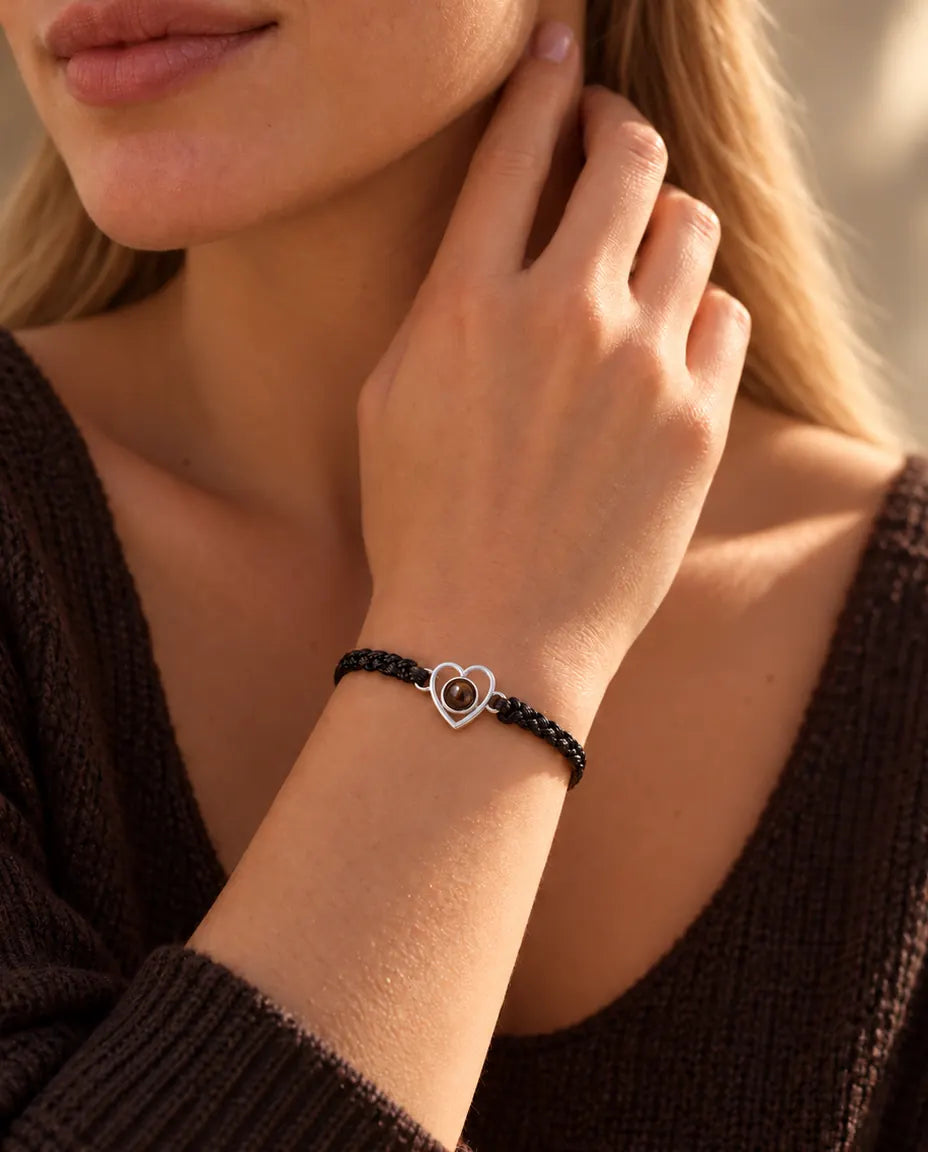 Femme, les doigts contre le cou, portant le bracelet cœur en argent sur cordon noir