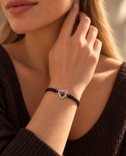 Femme, les doigts contre le cou, portant le bracelet cœur en argent sur cordon noir