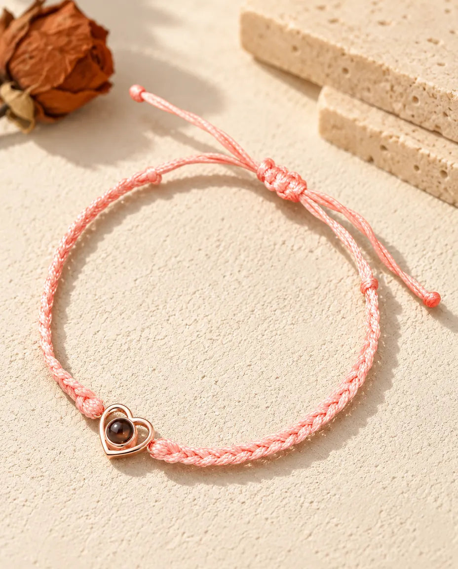 Cœur ouvert couleur or rose sur cordon tressé rose avec nœud coulissant réglable