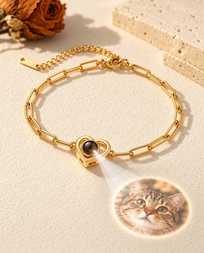 La lumière traverse la pierre brune du bracelet double cœur doré et projette une photo ronde