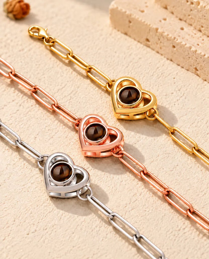 Gros plan de trois bracelets double cœur doré, or rose et argenté
