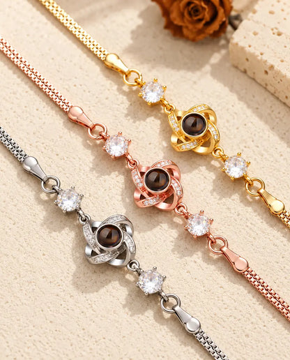 Gros plan de trois nœuds d'amour sertis de petits zircons, un de chaque couleur