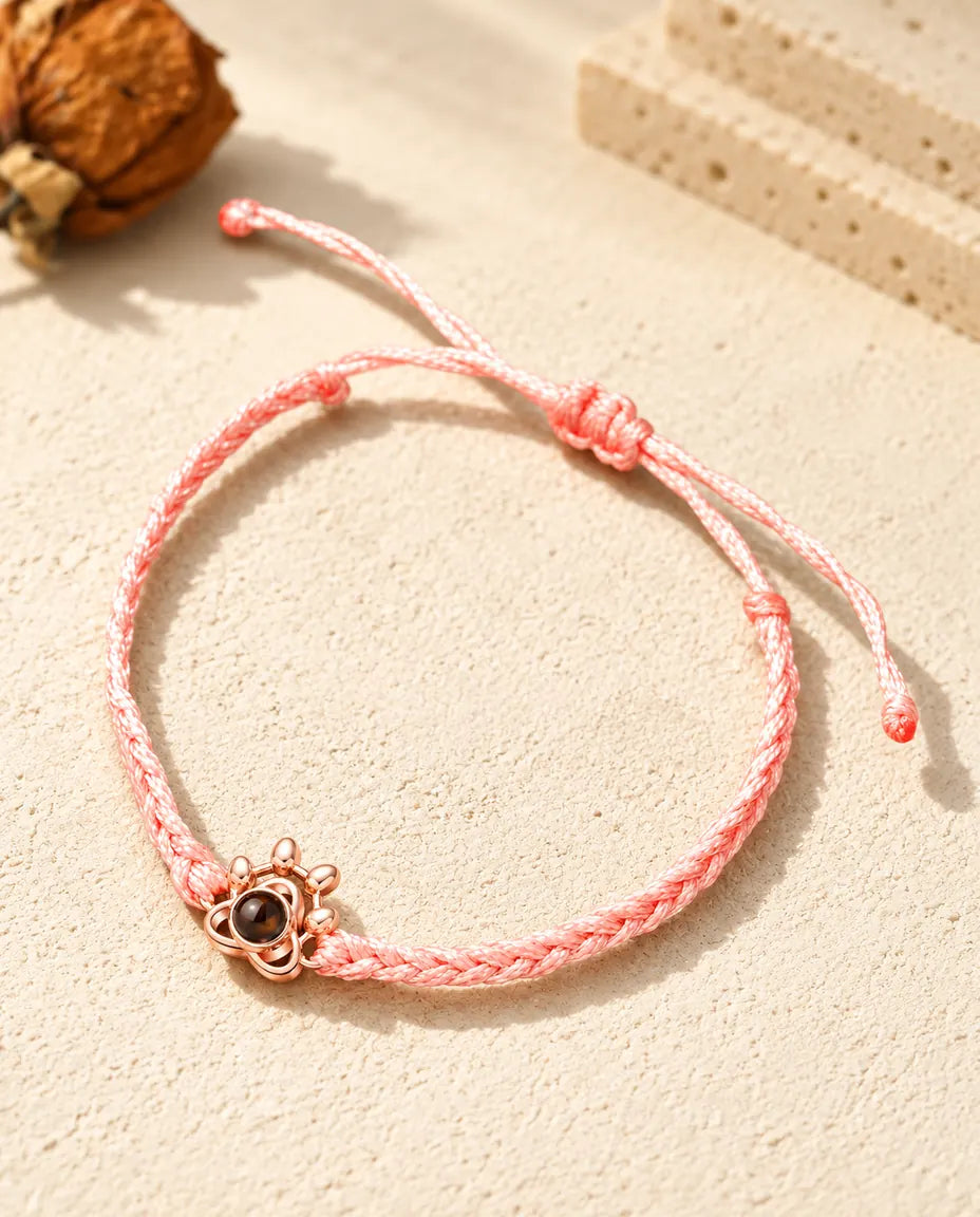 Charm patte couleur or rose sur cordon tressé rose avec nœud coulissant réglable