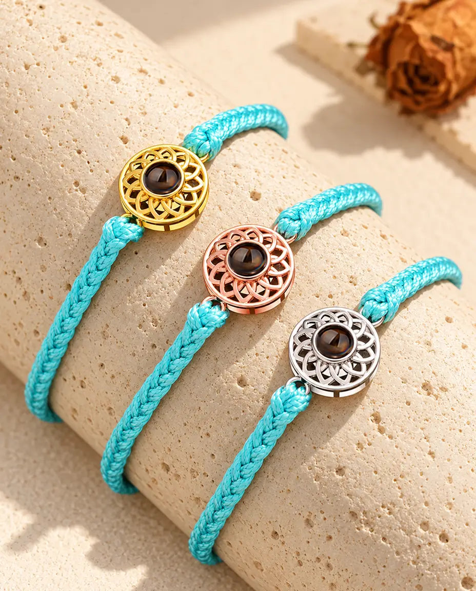 Bracelets cordon fin tressé bleu avec médaillon doré, or rose et argenté sur du travertin