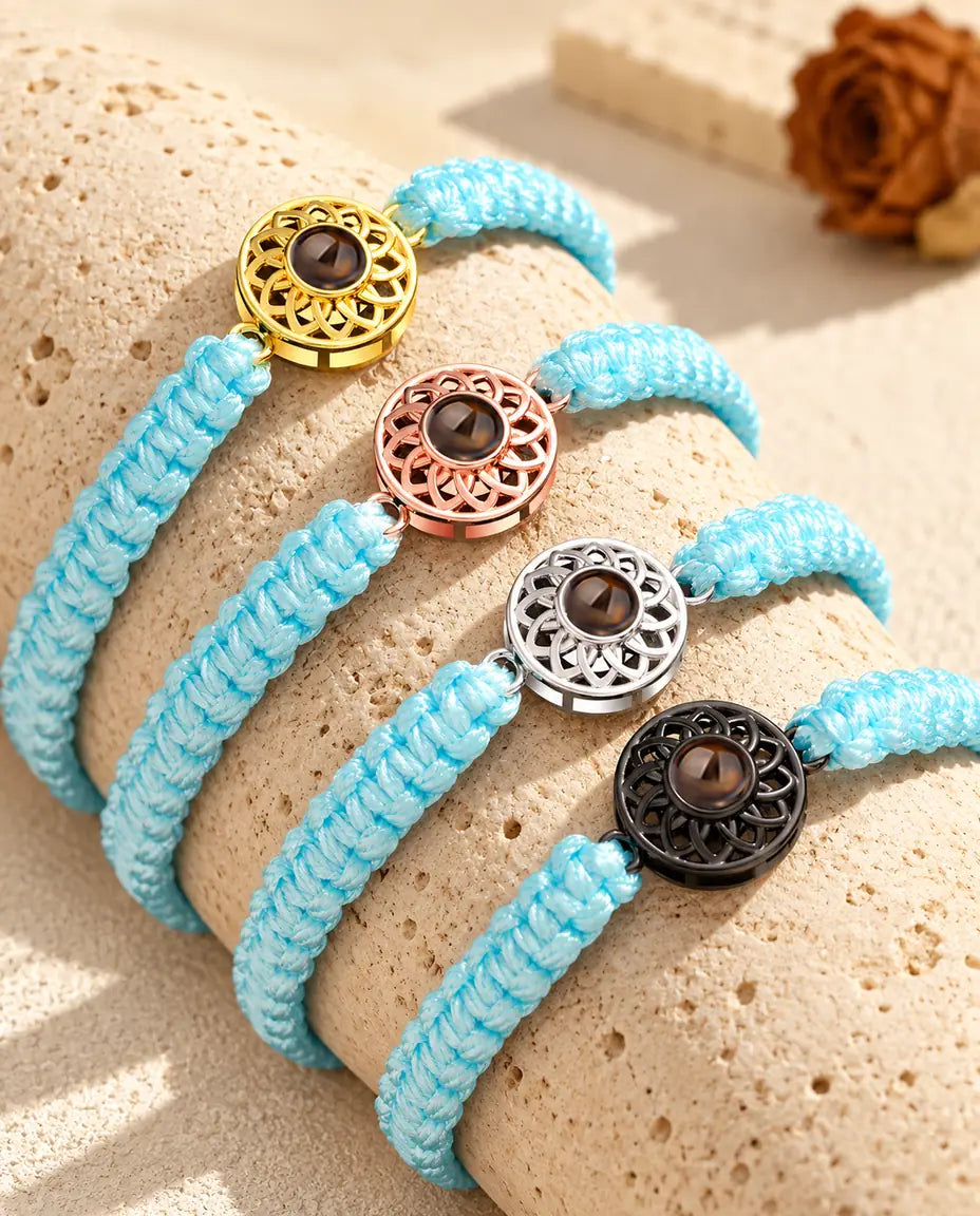 Bracelets cordon tressé bleu clair alignés sur du travertin, médaillon dans chaque couleur