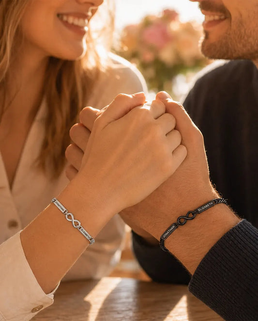 Bracelets Couple Personnalisés avec 2 Prénoms Gravés - Bracelets Infini Assortis Argenté et Noir - portés par un couple main dans la main