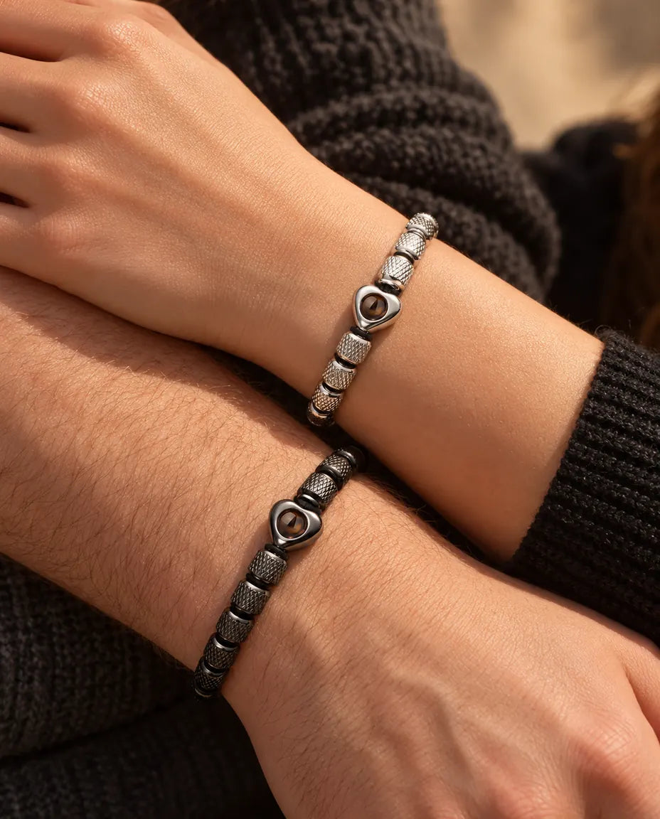 Gros plan de leurs poignets avec des bracelets à perle cœur assortis, argenté et noir