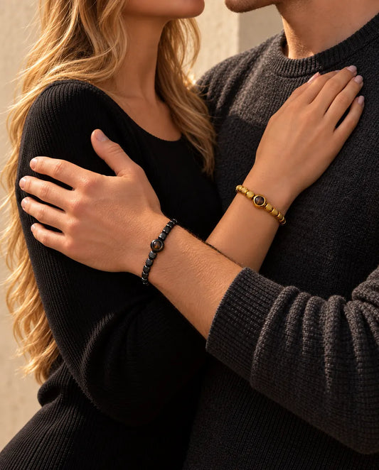 Couple enlacé : elle porte le bracelet de perles doré photo projection, lui le bracelet noir