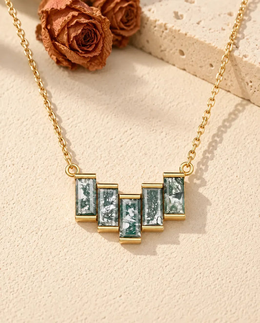 Collier Agate Mousse en Argent 925 Plaqué Or - posé sur une surface claire texturée près d’un bloc de travertin