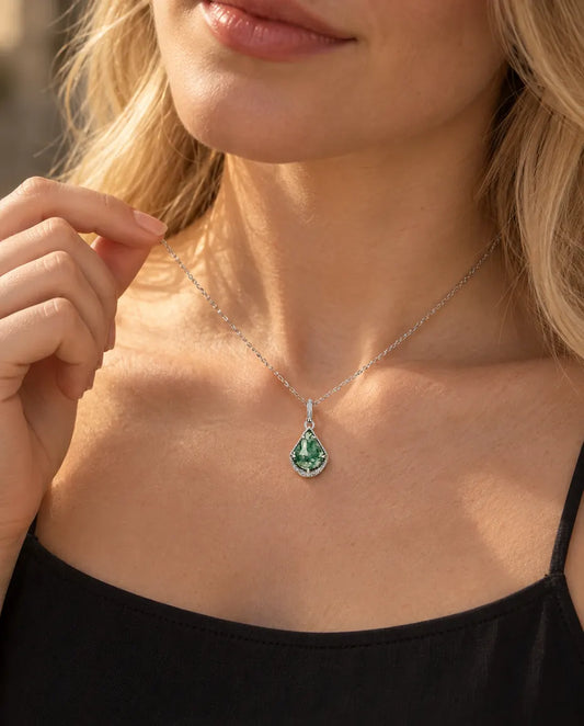 Collier Agate Mousse Écusson en Argent 925 - porté par un mannequin qui tient la chaîne du bout des doigts