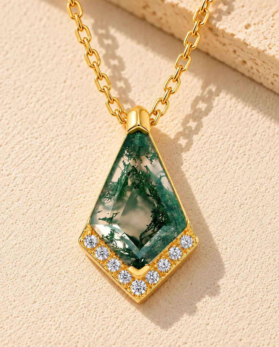 Collier Agate Mousse en Argent 925 Plaqué Or - posé sur une surface claire texturée près d’un bloc de travertin