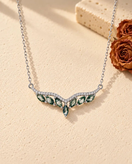 Collier Agate Mousse en Argent 925 - posé sur une surface claire texturée près d’un bloc de travertin