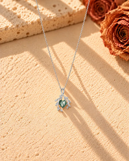 Collier Agate Mousse Cœur et Branches en Argent 925 - le collier entier posé en long V sur une surface claire texturée