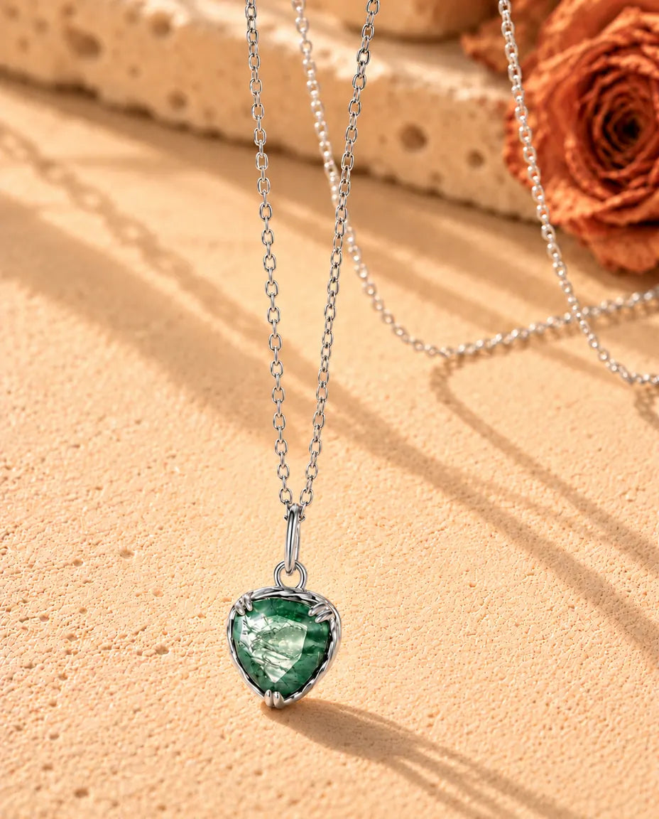Collier Pendentif Cœur Agate Mousse en Argent 925 - vu de biais sur une surface claire texturée