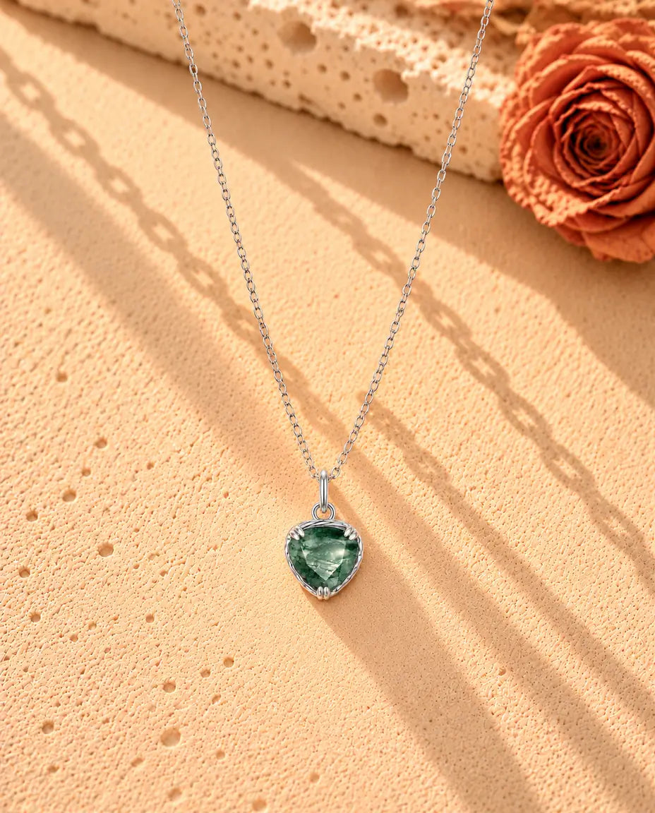 Collier Pendentif Cœur Agate Mousse en Argent 925 - le collier entier posé en long V sur une surface claire texturée