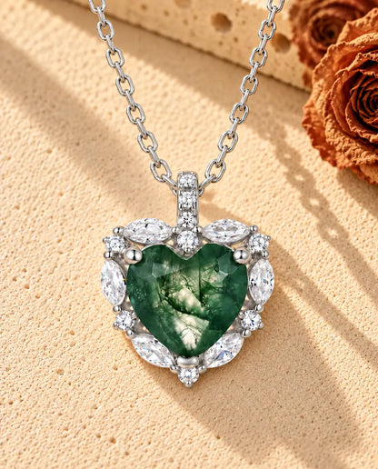 Collier Agate Mousse Cœur Halo en Argent 925 - posé sur une surface claire texturée près d’un bloc de travertin