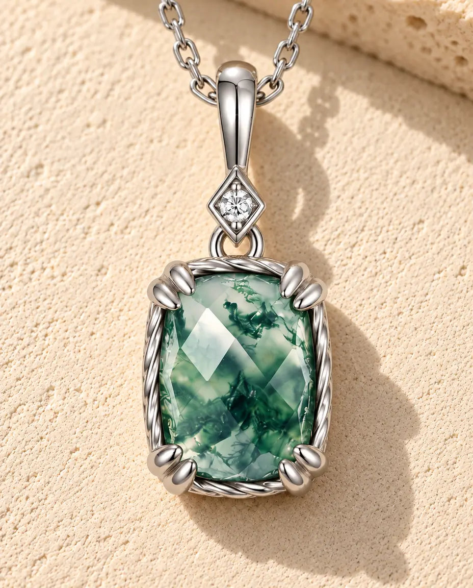 Collier Pendentif Agate Mousse en Argent 925 - posé sur une surface claire texturée près d’un bloc de travertin