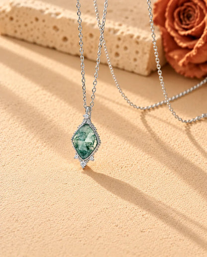 Collier Agate Mousse Losange en Argent 925 - vu de biais sur une surface claire texturée