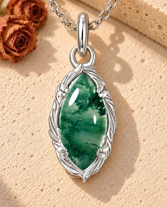 Collier Agate Mousse Marquise en Argent 925 - posé sur une surface claire texturée près d’un bloc de travertin