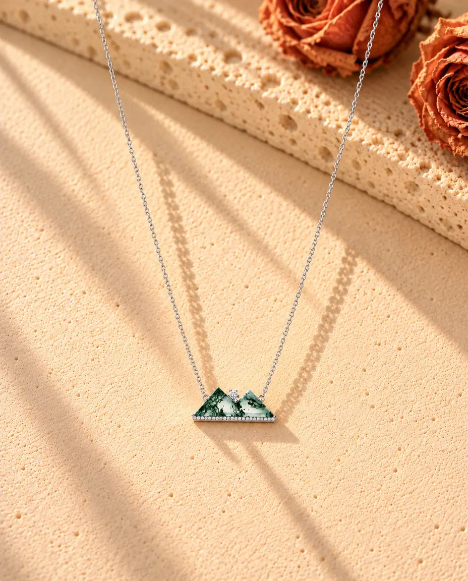 Collier Montagne Agate Mousse en Argent 925 - le collier entier posé en long V sur une surface claire texturée