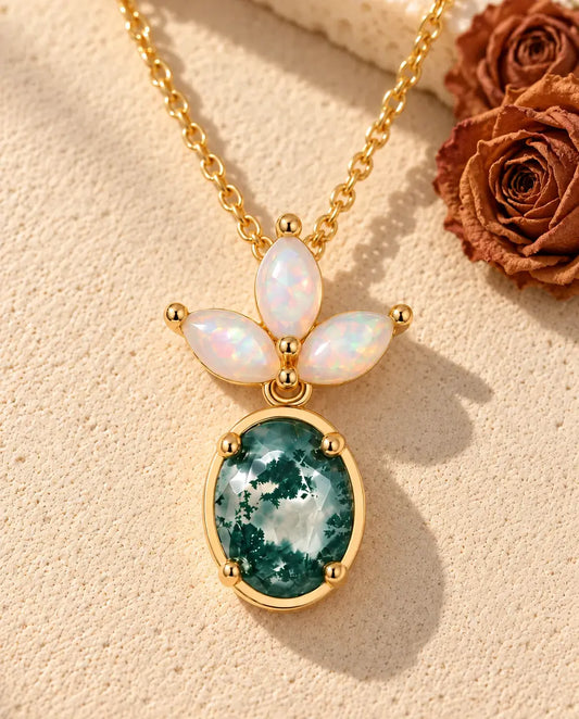 Collier Agate Mousse et Opale en Argent 925 Plaqué Or - posé sur une surface claire texturée près d’un bloc de travertin