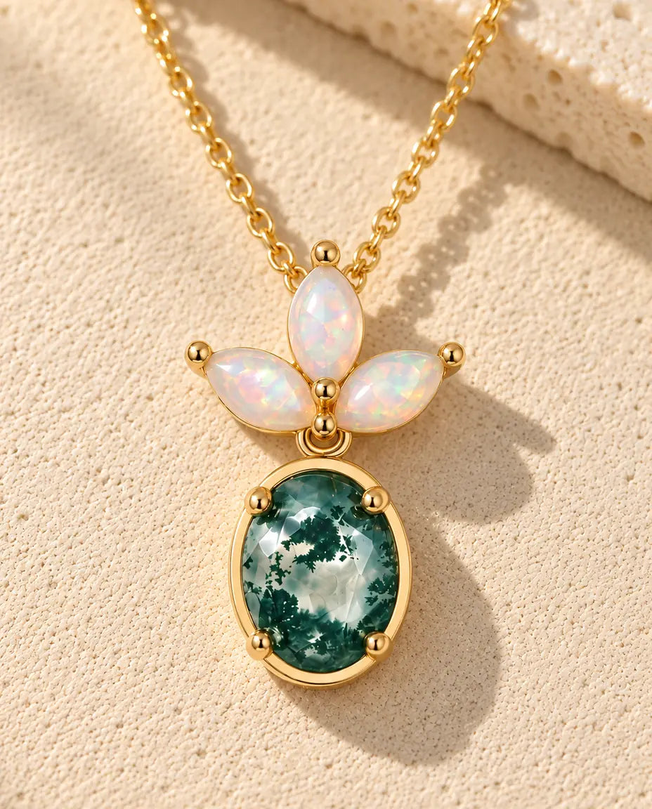 Collier Agate Mousse et Opale en Argent 925 Plaqué Or - posé sur une surface claire texturée près d’un bloc de travertin