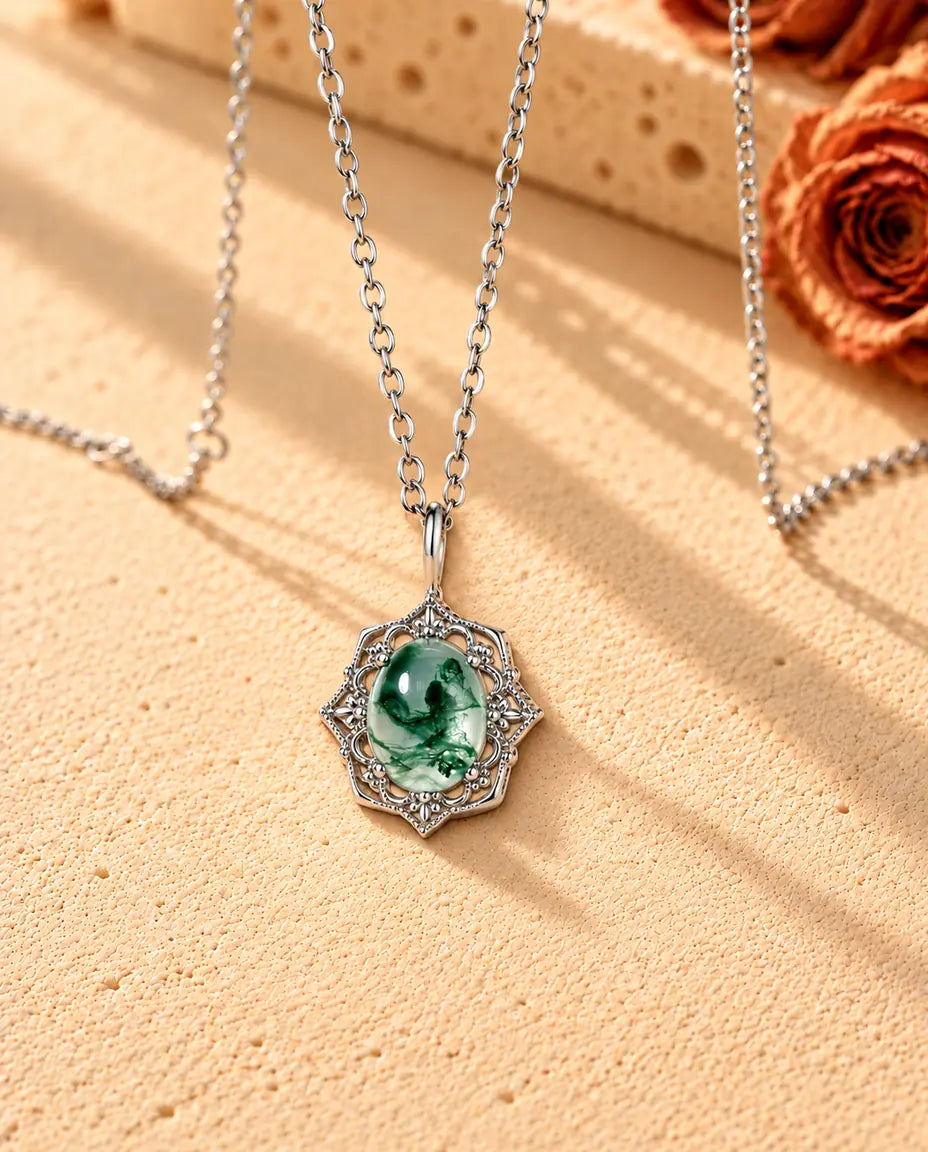 Collier Pendentif Agate Mousse Vintage en Argent 925 - vu de biais sur une surface claire texturée