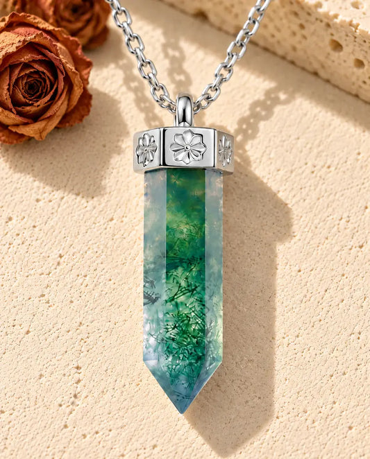 Collier Agate Mousse Pointe en Argent 925 - posé sur une surface claire texturée près d’un bloc de travertin