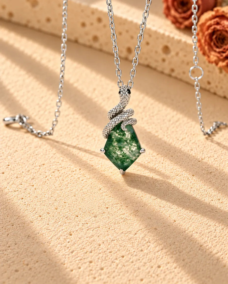 Collier Agate Mousse Serpent en Argent 925 - vu de biais sur une surface claire texturée