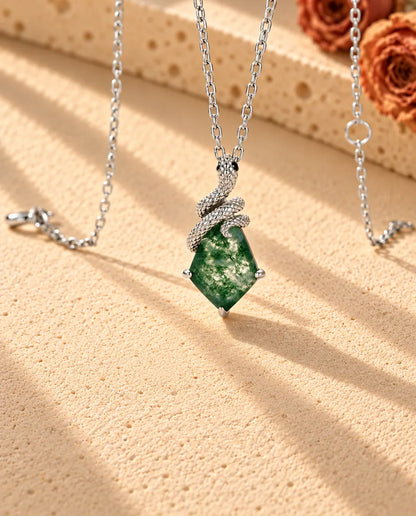 Collier Agate Mousse Serpent en Argent 925 - vu de biais sur une surface claire texturée