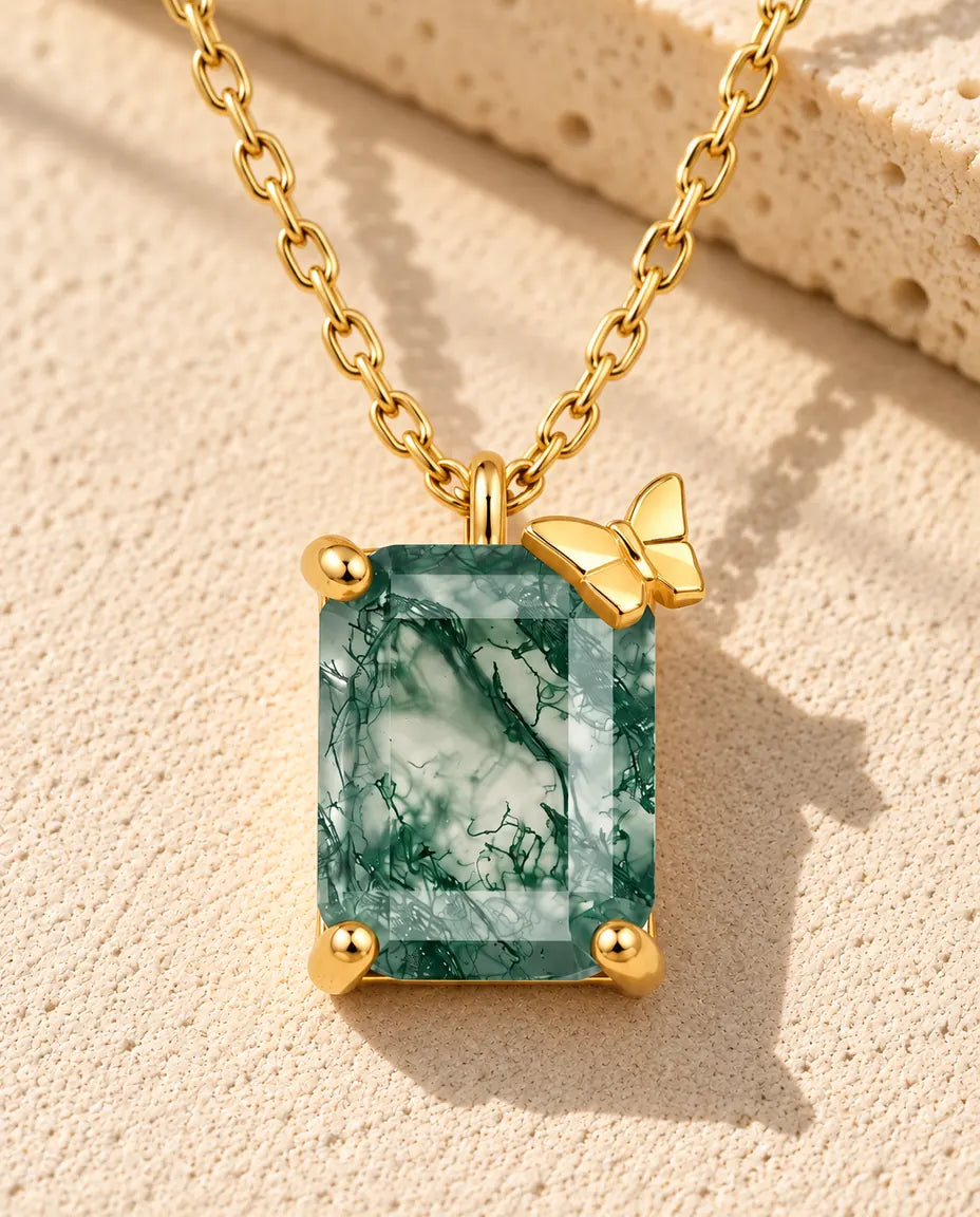 Collier Agate Mousse en Argent 925 Plaqué Or - posé sur une surface claire texturée près d’un bloc de travertin
