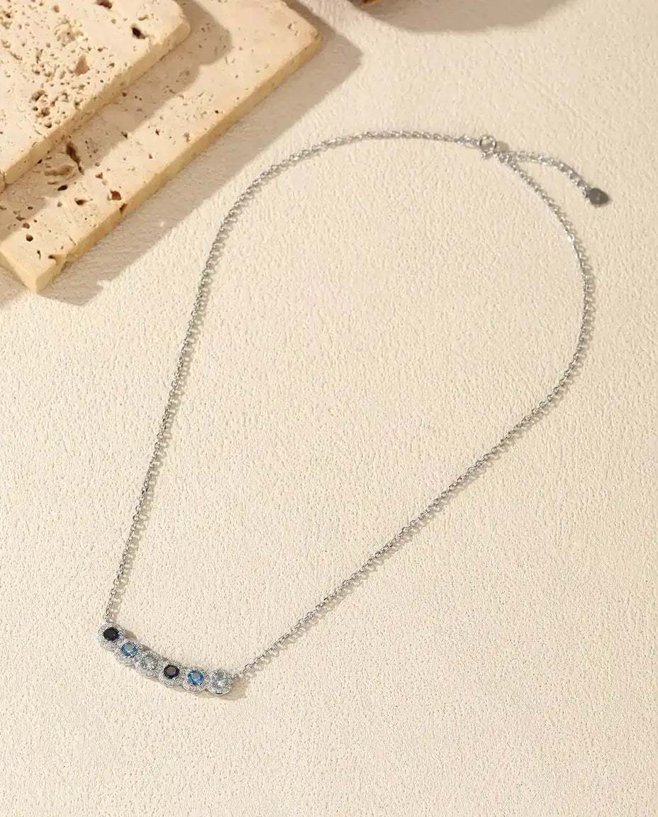 Collier Barre Dégradé Bleu - Six pierres bleues serties halo, barre courbe 34 mm, argent 925, 40+5 cm
