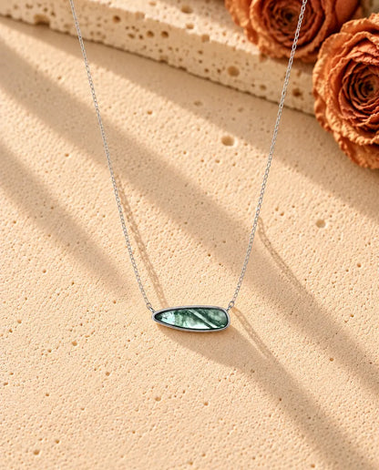 Collier Barrette Agate Mousse en Argent 925 - le collier entier posé en long V sur une surface claire texturée