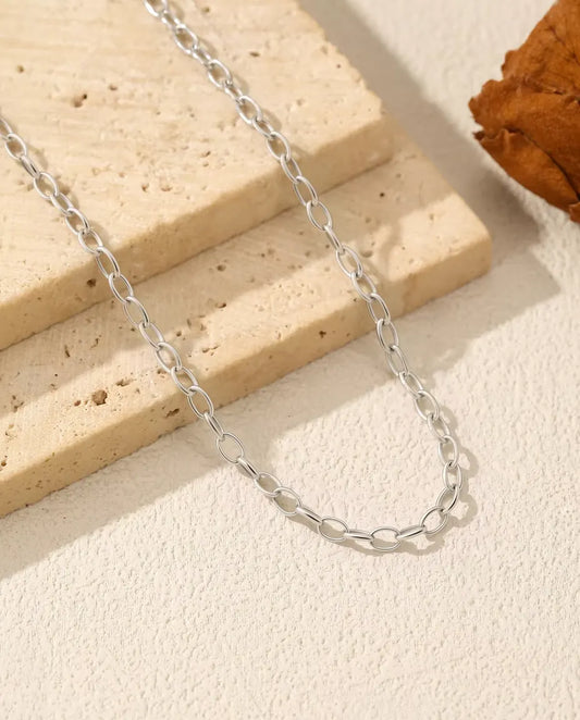 Collier Chaîne Forçat en Argent 925 - chaîne posée sur une dalle de travertin, gros plan