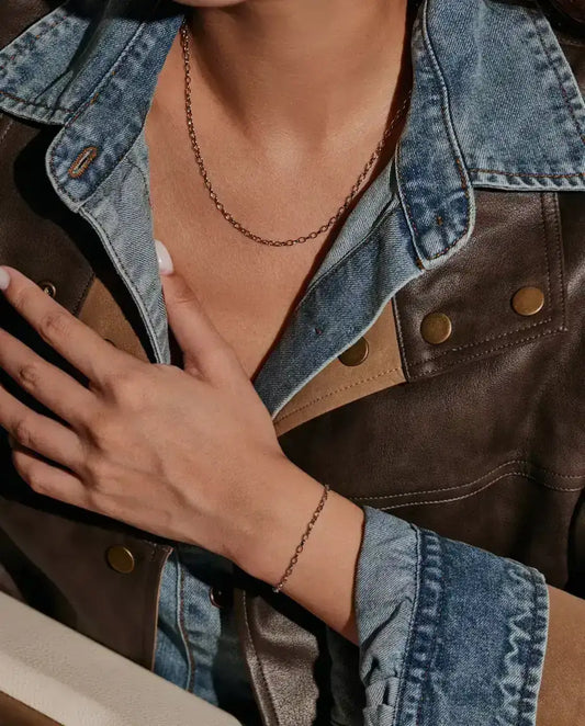 Collier Chaîne Forçat en Argent 925 - porté par un mannequin, main posée sur la poitrine