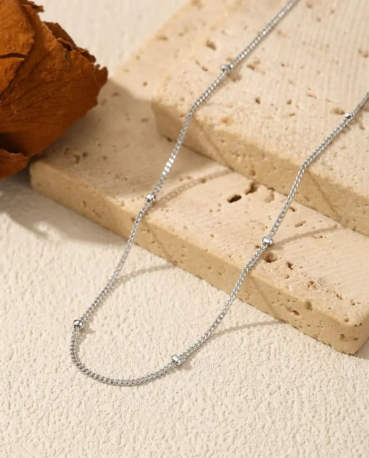 Collier Chaîne Satellite en Argent 925 - posé sur une surface claire près d’une dalle de travertin