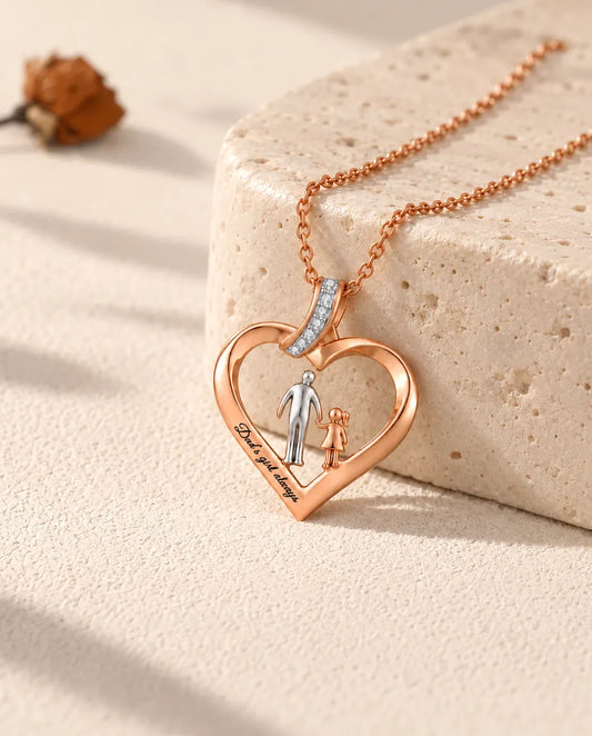 Collier cœur papa et fille personnalisé couleur or rose, posé contre un bloc de travertin