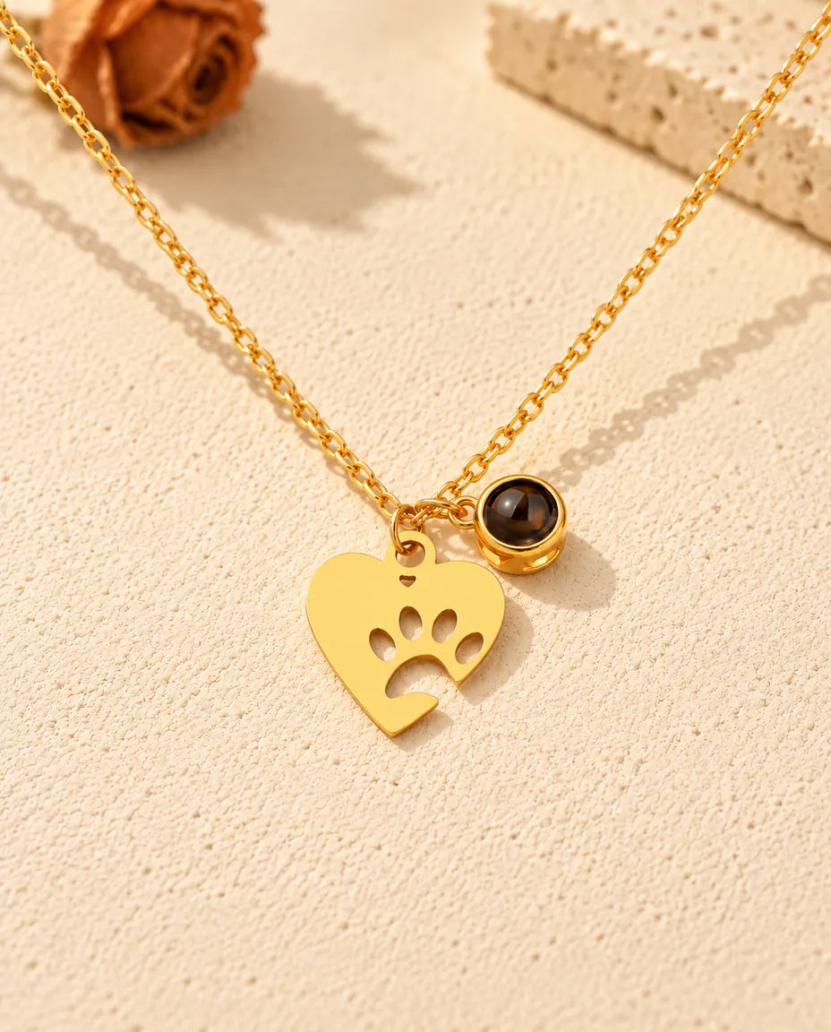 Vue de face du collier cœur patte doré avec sa petite pierre de projection