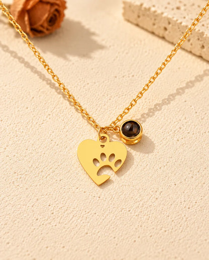 Vue de face du collier cœur patte doré avec sa petite pierre de projection