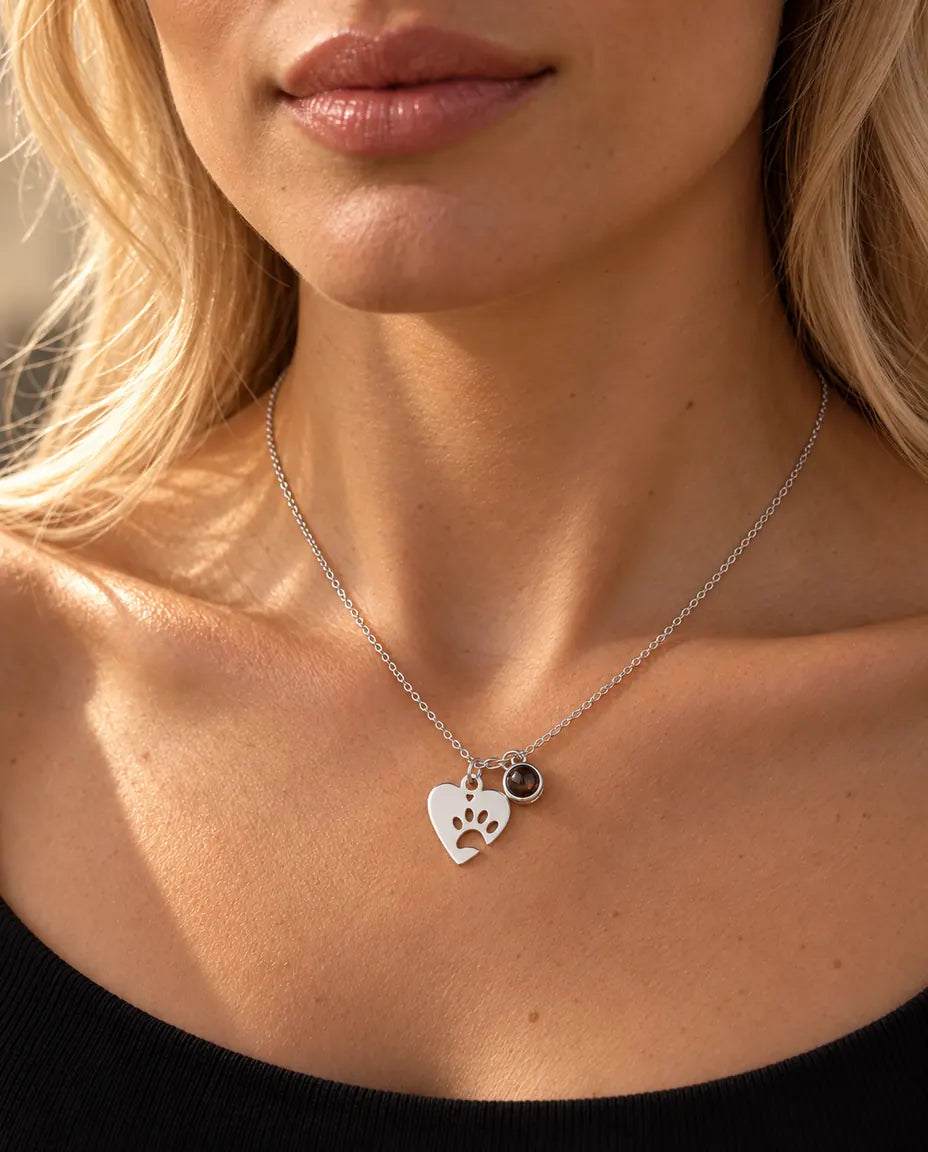 Femme en haut en maille noir portant le collier cœur patte argenté avec photo d'animal