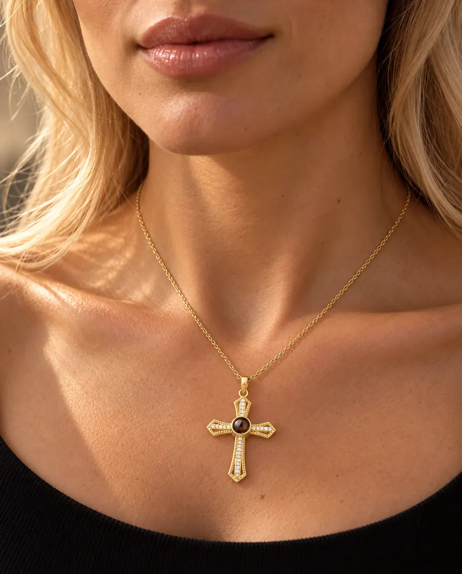 Femme blonde en haut noir portant le collier croix doré avec photo dans la pierre