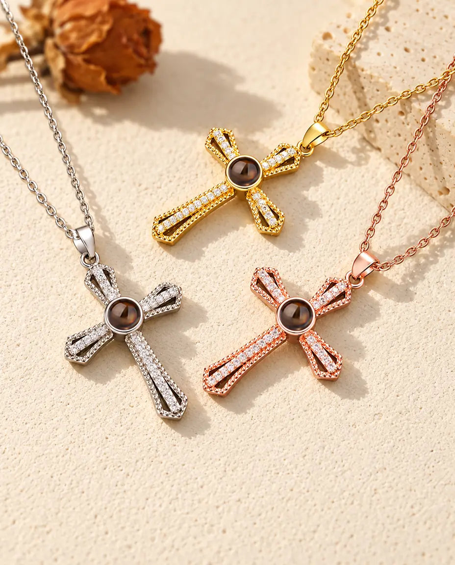 Croix argentée, dorée et couleur or rose à pierre brune près d'une dalle de travertin